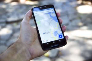 hand holding cell phone with GPS showing